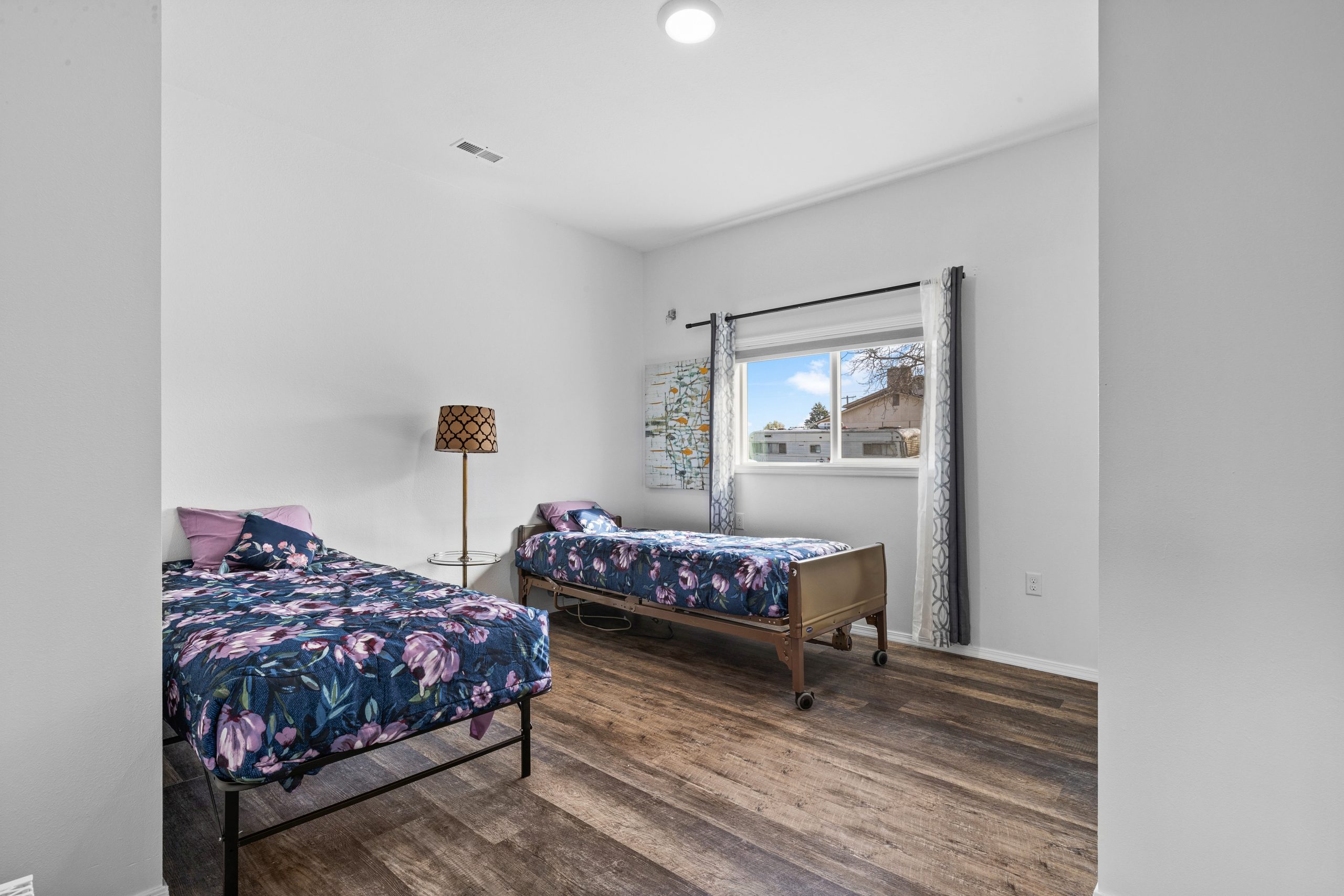 Shared bedroom with patterned bedding at Clarkston Care Home