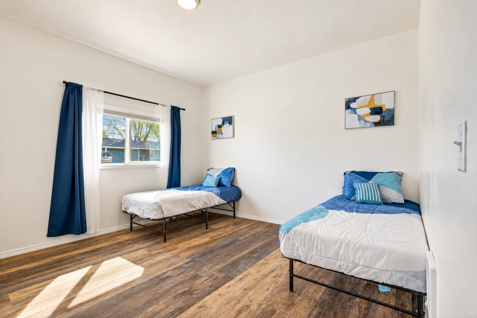 Shared bedroom with neatly arranged blue bedding at Clarkston Care Home